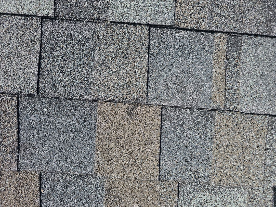 Close view of asphalt shingles with hail damage